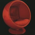 Eero Aarnio. Produziona: Asko Finnternational, 1966 - Sedia Globe, 1962-5. Fibra di vetro rossa, tessuto e base in metallo dipinto.  V&A Images / Victoria and Albert Museum, Londra
