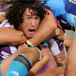 A Melbourne storm player screams while getting tackled by gold coast titans players in Australia