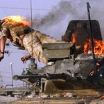 Settembre 2005: un miliare inglese si lancia fuori da un blindato in fiamme a Basra, in Iraq (Atef Hassan/Reuters)