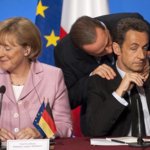 Ottobre 2008: il presidente del Consiglio Silvio Berlusconi parla con il presidente francese Nicolas Sarkozy e la cancelliera tedesca Angela Merkel durante un summit sulla crisi economica a Parigi (Philippe Wojazer/Reuters)