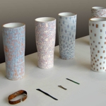 Emerso - Vasi in ceramica<br>Attese Edizioni - 2009<br>Una serie di strati di ceramica (ingobbi) di diversi colori si sovrappongono sulla superficie del vaso. Prima della cottura finale vengono lavorati dal progettista con diversi strumenti come carta abrasiva, spazzole metalliche, mole, lame ecc. in modo da produrre delle leggere scalfitture che fanno emergere gli strati colorati ogni volta in modo diverso