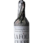 La folle guerra di Bush<br>Etichetta per vino realizzata per la mostra "Message on the bottle"<br>Amburgo - 2007<br>La bottiglia di vino  avvolta nella carta di giornale, come quando la si acquista dal droghiere. In questo modo, il titolo di un articolo del giornale ci appare come l'etichetta del vino trasformando il messaggio in esso contenuto da casuale a esplicitamente intenzionale e comunicativo